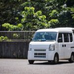 荷物を積み込む白い軽バン