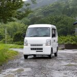 砂利道を走る白い軽バン