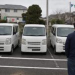 中古車店で軽バンを見るお客様