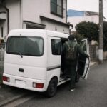 軽バンの運転席に乗り込む作業着の後ろ姿